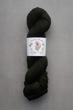 Load image into Gallery viewer, Dark green skein of yarn with a label on a gray background