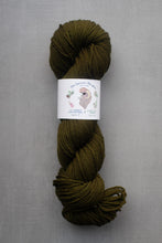 Load image into Gallery viewer, Olive green skein of yarn with a label on a gray background