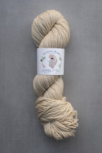 Load image into Gallery viewer, Ball of beige yarn with a label on a gray background