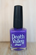 Load image into Gallery viewer, Purple nail polish bottle with black cap labeled &#39;Death Valley Nails&#39; on a wooden surface.