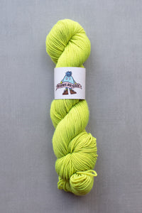 Bright green skein of yarn with a label on a gray background