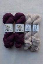 Load image into Gallery viewer, Four skeins of yarn arranged side by side on a light gray textured fabric background. The left two skeins are a deep burgundy/maroon color, and the right two skeins are a light oatmeal/beige color.