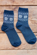 Load image into Gallery viewer, Pair of blue socks with white patterns on a wooden surface