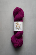 Load image into Gallery viewer, A skein of deep magenta-purple yarn with a white paper label featuring a ram illustration