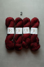 Load image into Gallery viewer, Four skeins of deep burgundy yarn arranged side by side on a light gray textured background, with a small black number 2 printed above them. Each skein has a white paper label with a bird illustration.