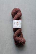 Load image into Gallery viewer, Ball of brown yarn with a label on a gray background