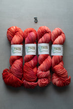 Load image into Gallery viewer, Four skeins of red yarn with labels on a gray background