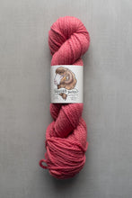 Load image into Gallery viewer, Pink skein of yarn with a label on a gray background