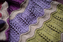 Load image into Gallery viewer, Close-up of a knitted fabric with wavy pattern in purple, green, and beige.