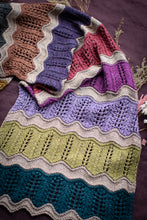 Load image into Gallery viewer, Colorful knitted blanket with wavy pattern on a dark background