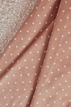 Load image into Gallery viewer, Close-up of pink fabric with white polka dots on a textured surface