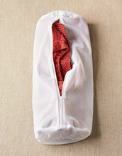 Load image into Gallery viewer, White garment bag with a red sweater inside on a beige background