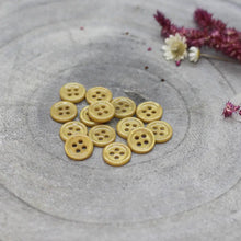 Load image into Gallery viewer, Yellow buttons on a textured gray surface with flowers