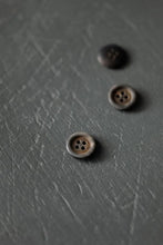Load image into Gallery viewer, Three brown buttons on a textured gray surface