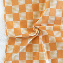 Load image into Gallery viewer, Checkered fabric with orange and white pattern on a textured surface