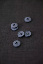 Load image into Gallery viewer, Set of gray buttons on a textured brown fabric background