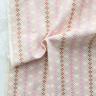 Close-up of a folded fabric with a pink and brown checkered pattern on a white background