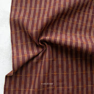 Plaid fabric with brown and beige pattern on a white background, featuring the brand 'Fableism'.