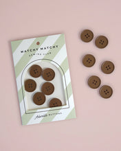 Load image into Gallery viewer, Set of brown buttons with packaging labeled 'Matchy Matchy Sewing Club' on a pink background
