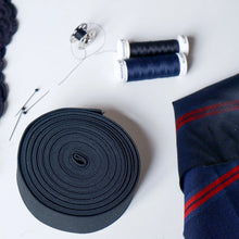 Load image into Gallery viewer, Navy blue fabric roll, spool of thread, and sewing accessories on a white background