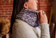 Load image into Gallery viewer, A close-up lifestyle shot of a woman wearing a knitted cowl neck warmer. The neck warmer features a textured pattern of purple, gray, and black yarn.