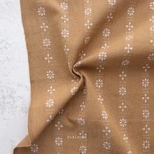 Load image into Gallery viewer, Brown fabric with white floral patterns on a textured surface