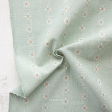 Load image into Gallery viewer, Light green fabric with subtle floral embroidery on a textured white background