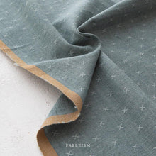 Load image into Gallery viewer, Close-up of teal fabric with a subtle pattern on a white background, featuring the brand 'Fableism'.