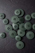 Load image into Gallery viewer, Green buttons scattered on a dark surface