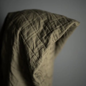 Quilted green fabric on a gray background