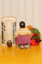 Load image into Gallery viewer, A handmade French textile doll dressed in a yellow and white striped sweater and a red-and-white striped skirt, standing on a yellow surface next to a wooden 'L'Aide-Memoire' memory board and a small basket.
