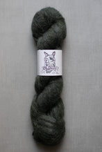 Load image into Gallery viewer, Dark gray skein of yarn with a label on a gray background