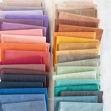 Load image into Gallery viewer, Row of folded fabric swatches in various colors on a white background