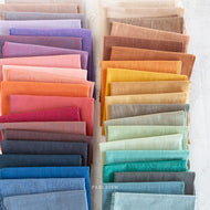 Row of folded fabric swatches in various colors on a white background