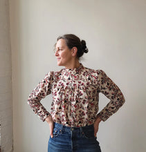 Load image into Gallery viewer, Woman wearing a floral blouse and jeans against a plain wall.