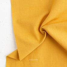 Load image into Gallery viewer, Close-up of yellow fabric with 'Fableism' branding on a white background