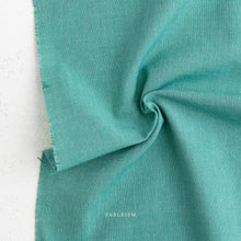 Load image into Gallery viewer, Close-up of teal fabric with 'Fabletics' branding on a white background