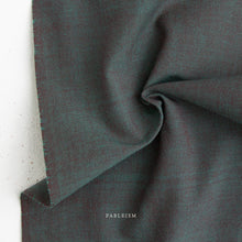 Load image into Gallery viewer, Close-up of dark green fabric with 'Fableism' branding.