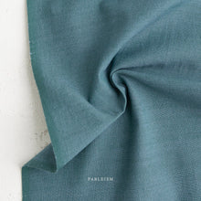 Load image into Gallery viewer, Close-up of teal fabric with 'Fableism' branding on a light background