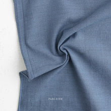 Load image into Gallery viewer, Close-up of blue fabric with 'Fableism' branding on a light background