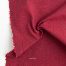Load image into Gallery viewer, Close-up of red fabric with 'Fableism' branding on a white background