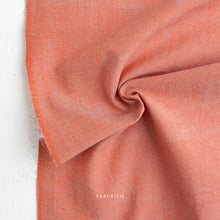 Load image into Gallery viewer, Close-up of a folded piece of coral-colored fabric with 'Fableism' branding.