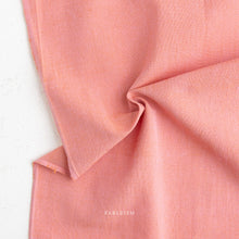 Load image into Gallery viewer, Close-up of pink fabric with 'Fableism' branding on a white background